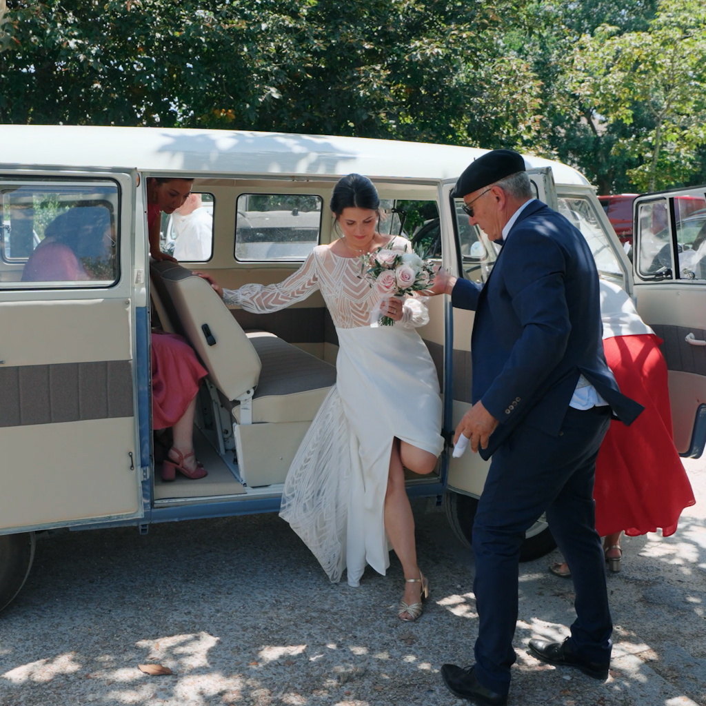 La mariée sort de sa voiture aidée par son père lors de son mariage, cette photo est sortie de leur film de mariage réalisé par un vidéaste de mariage basé à Toulouse.